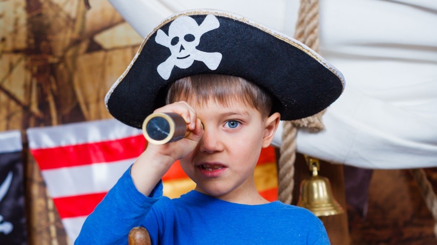 wee boy dressed up in a pirate tricorn, holding a telescope