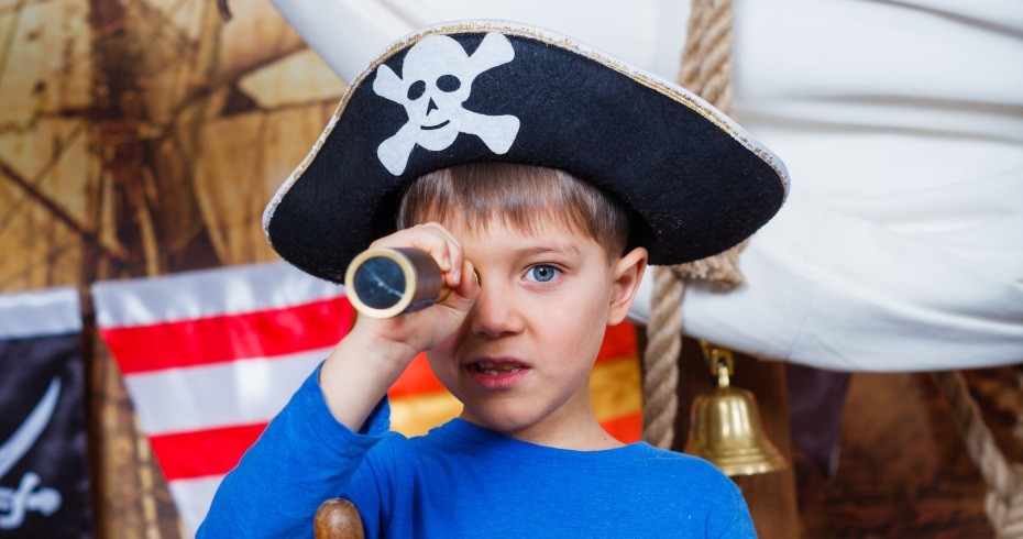 wee boy dressed up in a pirate tricorn, holding a telescope