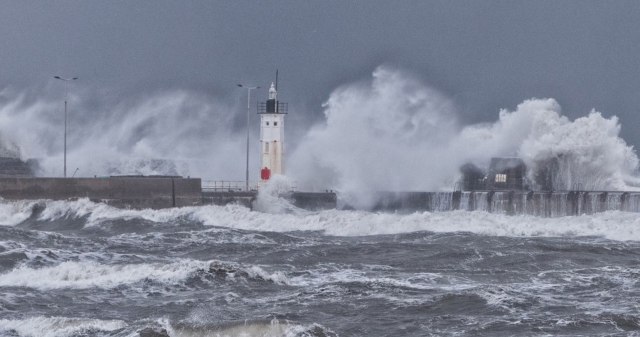 photograph of pier with dramatic waves crashing over it