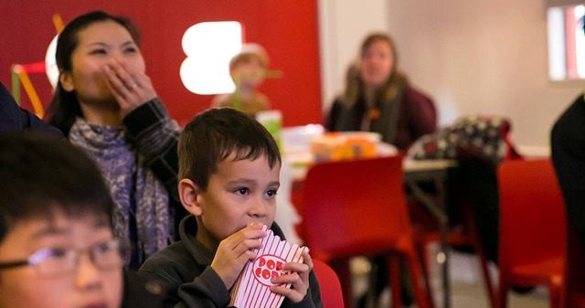 image of children and parents eating popcorn in the red box at verdant works