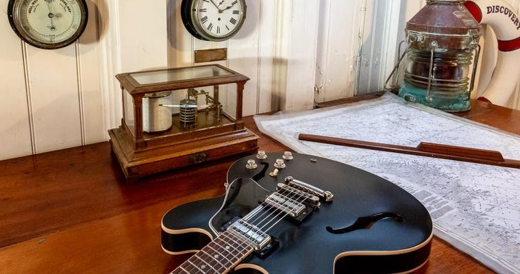 image of guitar with kit from discovery in background