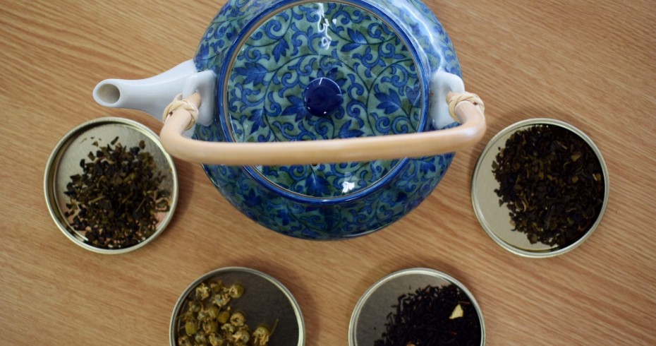 image of tea pot surrounded by containers of various teas