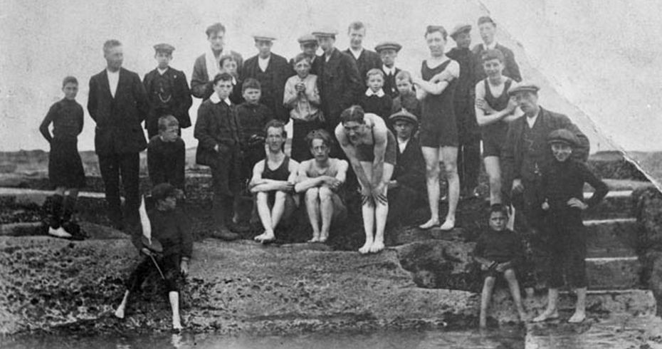 black and white photo of group of men and boys at tidal pool