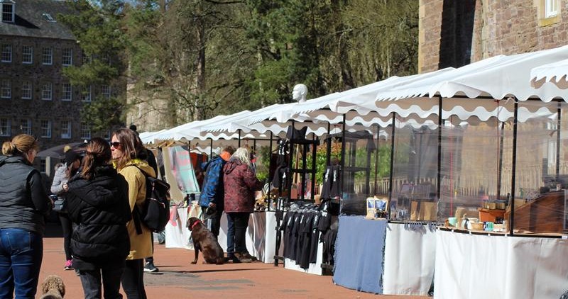 people visiting stalls at outdoor market at new lanark