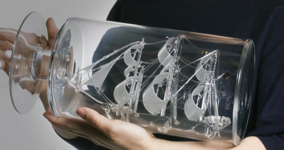 glass ship in bottle being held by human hands glass ship in bottle being held by human hands